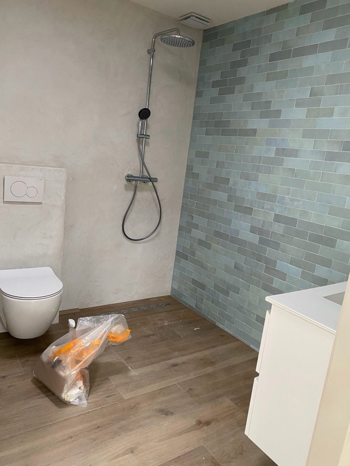 Nieuwe badkamer met regendouche, hangtoilet en groene wandtegels