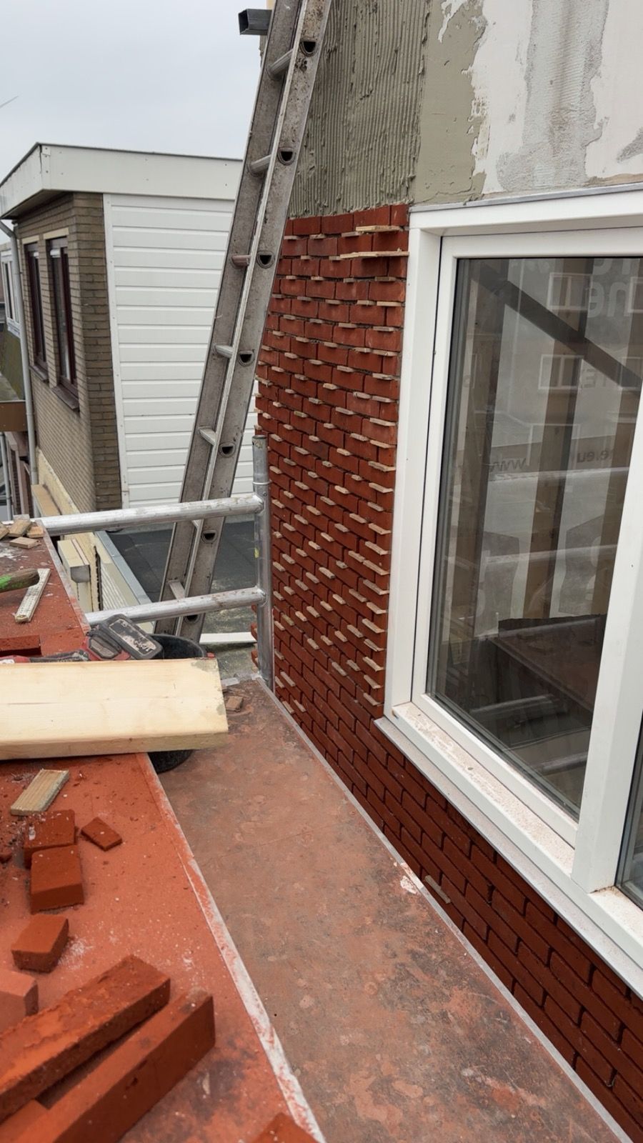 Nieuw opgemetselde bakstenen gevel met steigerwerk